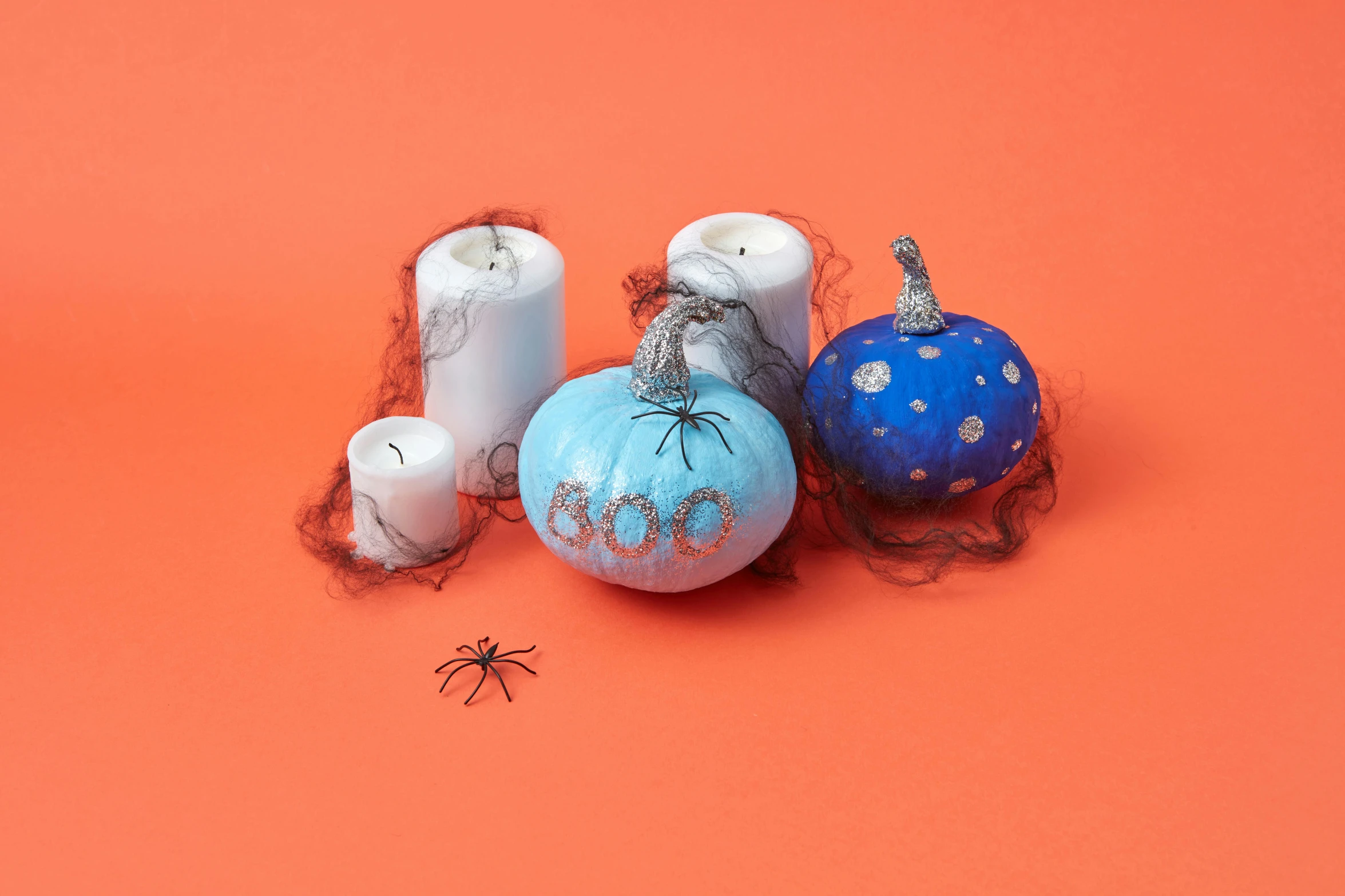 a group of halloween decorations on an orange background, by Jeka Kemp, blue paint on top, candles, blue and grey theme, goop