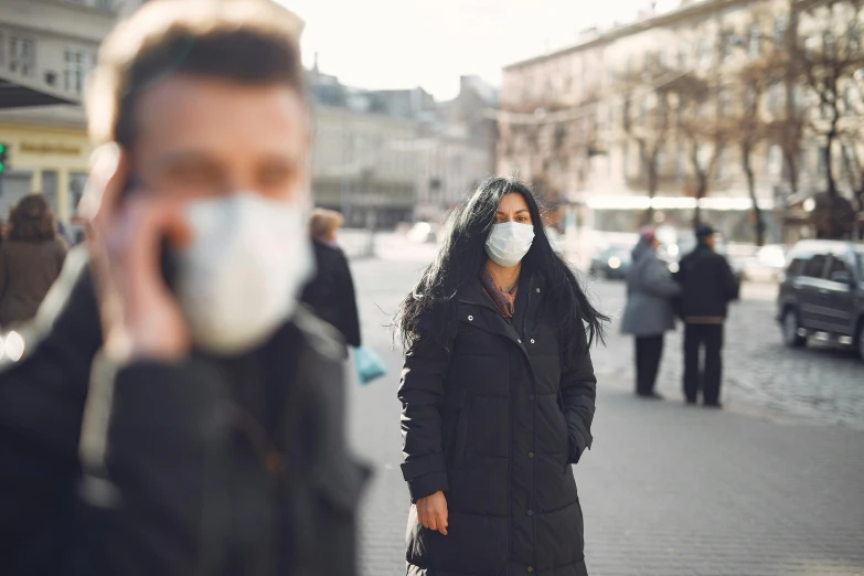 a woman walking down a street talking on a cell phone, by Adam Marczyński, trending on pexels, renaissance, medical mask, people panic in the foreground, man and woman walking together, air pollution