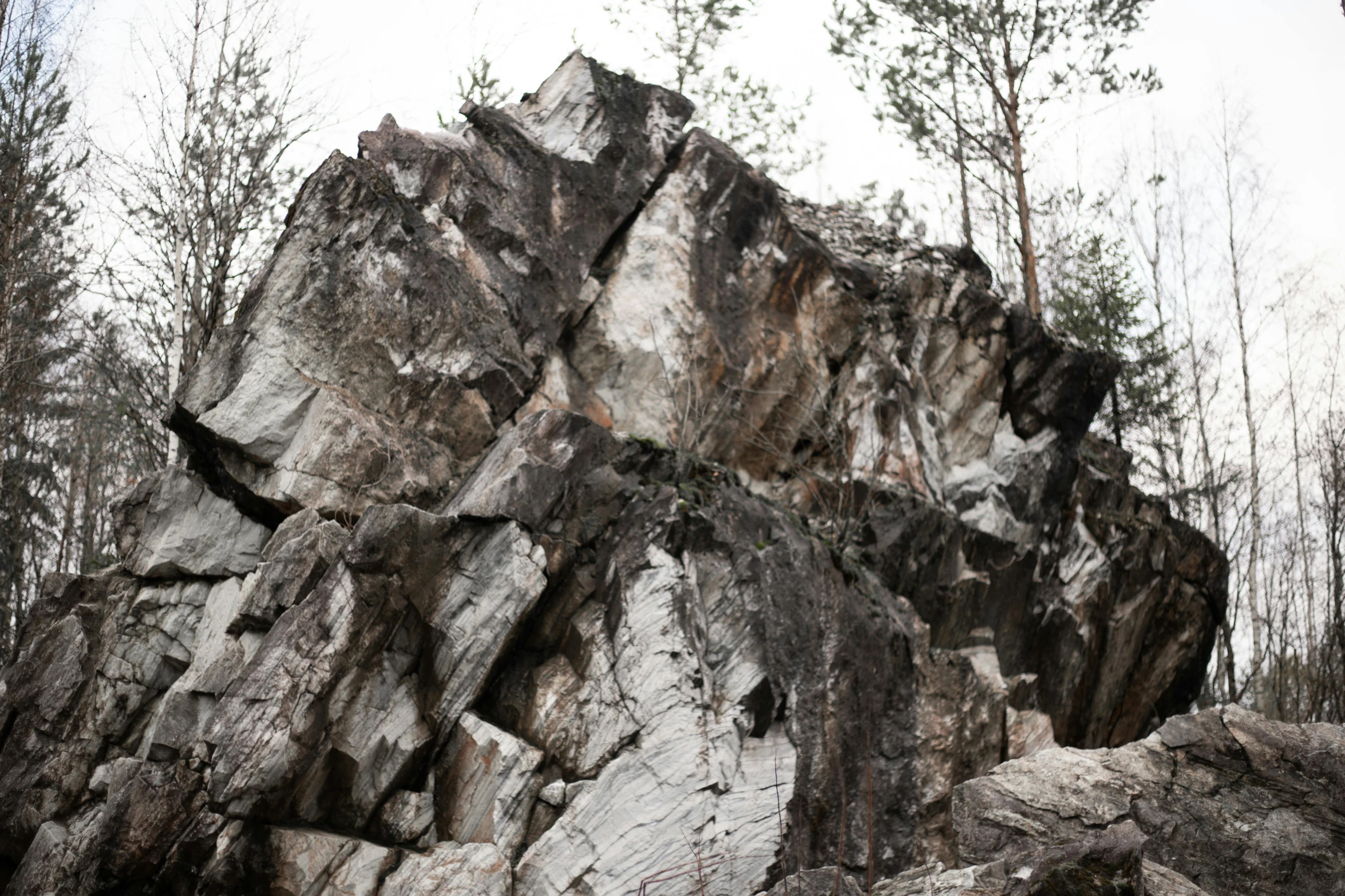 a large rock in the middle of a forest, by Jaakko Mattila, unsplash, tessellated planes of rock, all marble, landslides, 2000s photo