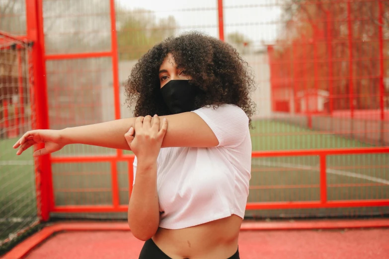 a woman standing on top of a tennis court holding a racquet, trending on pexels, graffiti, balaclava covering face, wearing crop top, mixed-race woman, wearing bandit mask