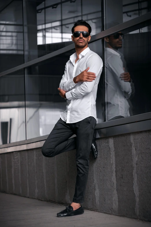 a man leaning against a wall with his arms crossed, inspired by david rubín, pexels contest winner, long shirt, elegant floating pose, wearing pants, high quality upload