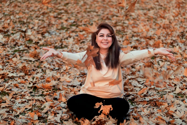 a woman sitting on top of a pile of leaves, pexels contest winner, hurufiyya, beautiful iranian woman, with a happy expression, avatar image, beige
