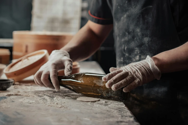 a close up of a person putting something in a bottle, a marble sculpture, pexels contest winner, woodfired, australian, restoration, cardboard