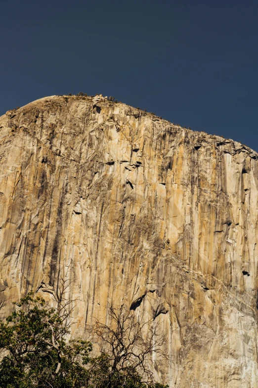 a large rock face with a blue sky in the background, el capitan, coliseum, 8k resolution”, manuka