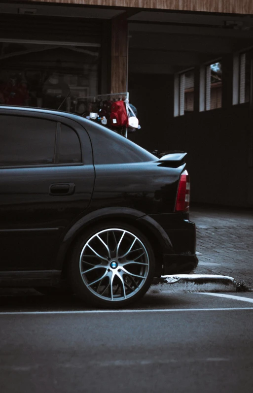 a black car parked in a parking lot, hsv, rim lit, slick tires, tight shot of subject