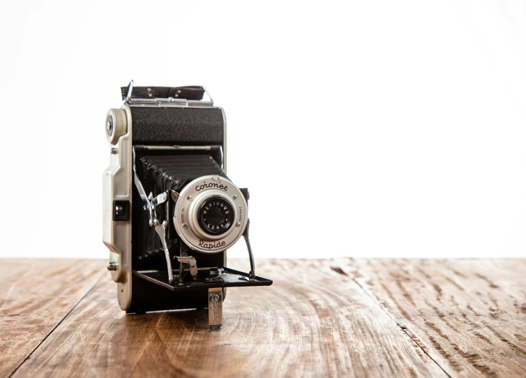 an old camera sitting on top of a wooden table, by Glennray Tutor, unsplash, bauhaus, medium - format print, 1950, studio medium format photograph, medium-format print