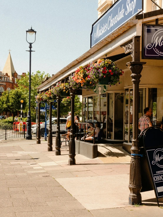 a group of people walking down a sidewalk next to a building, maryport, michelin starred restaurant, marketsquare, gazebos