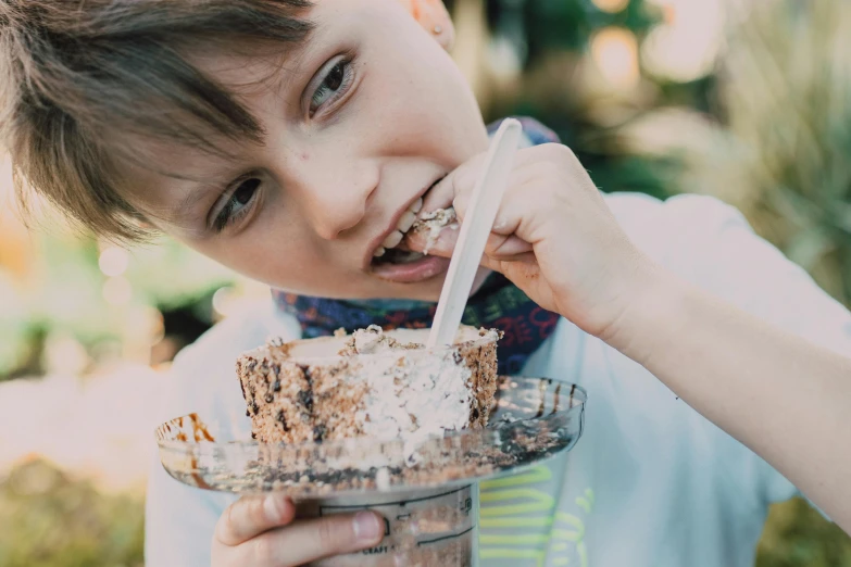 a young boy eating an ice cream sundae, by Lee Loughridge, pexels, happening, baking a cake, avatar image, closeup - view, people outside eating meals