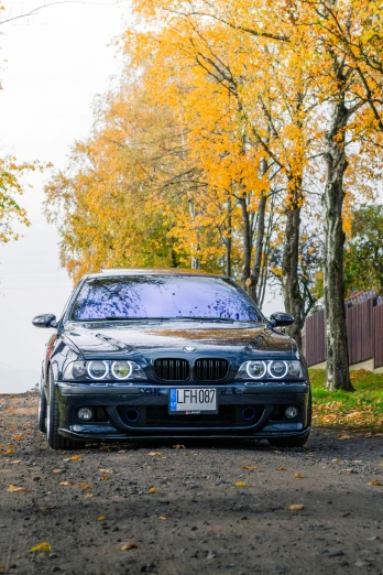 a couple of cars parked next to each other on a dirt road, by Anato Finnstark, during autumn, bmw, low quality photo, frontal