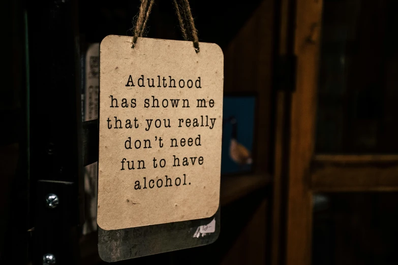 a sign that says adulthood has shown the that you really don't need fun to have alcohol, by Hugh Adam Crawford, a photograph of a rusty, decoration, medium close up shot, a wooden