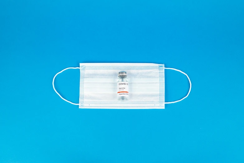 a medical mask on a blue background, by Jan Rustem, vials, one single mask, detailed product image, white head