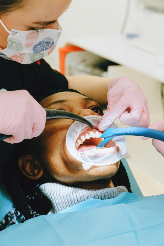 a woman getting her teeth brushed by a dentist, pexels contest winner, renaissance, long open black mouth, plating, kezie demessance, a high angle shot