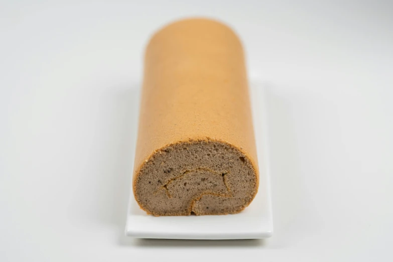 a roll of bread sitting on top of a white plate, sandy beige, detailed product image, dessert, a long-shot from front