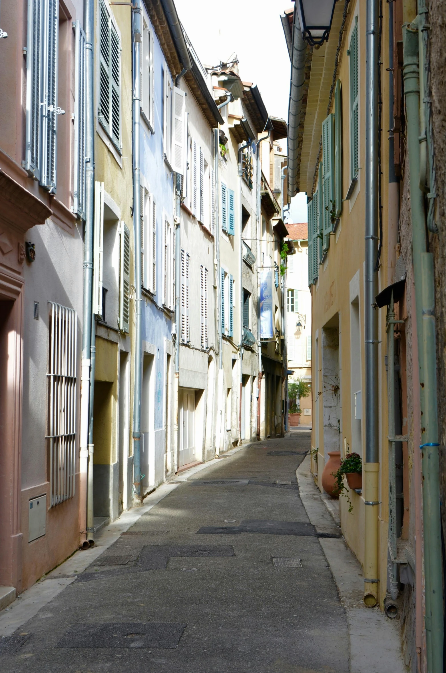 a narrow street is lined with colorful buildings, inspired by Raoul Dufy, flickr, soft colors, cannes, pitt