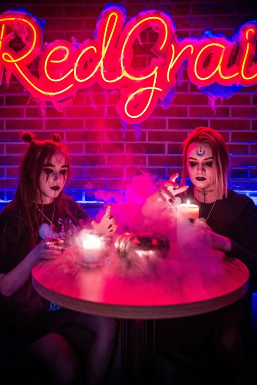 two women sitting at a table in front of a neon sign, trending on reddit, krampus, smoke grenades, high quality photo, magical cauldron