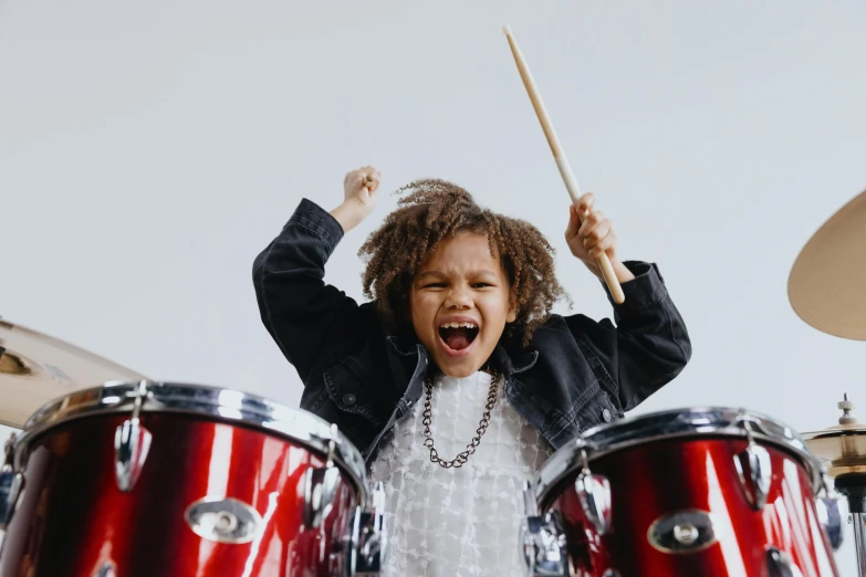 a little girl that is playing with some drums, an album cover, pexels contest winner, all overly excited, thunderous, he is a rockstar, gen z