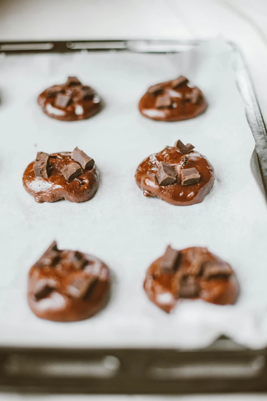 a pan filled with chocolate covered cookies on top of a table, by Jessie Algie, pexels, process art, made of glazed, soft shapes, thumbnail, lush