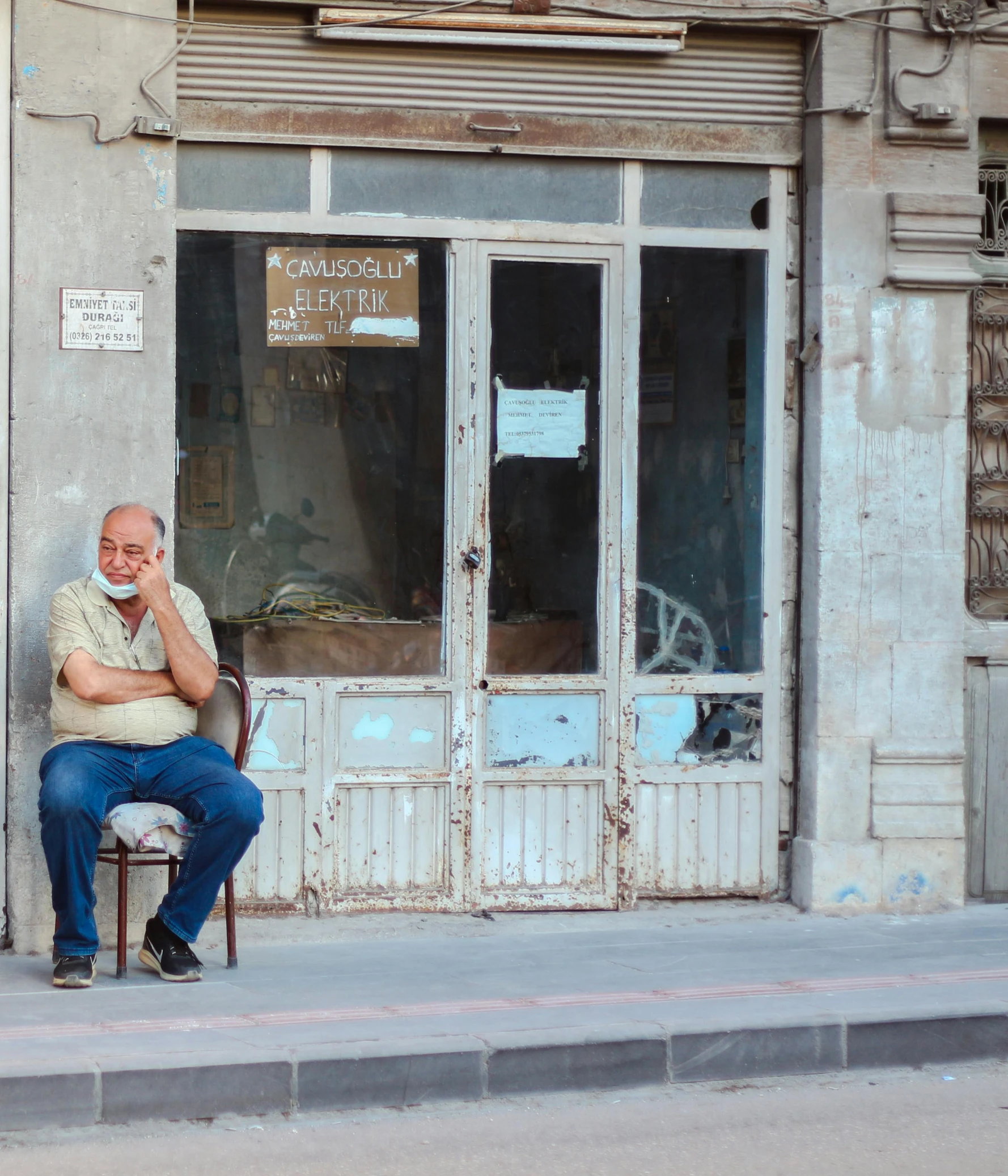 a man sitting on a chair talking on a cell phone, pexels contest winner, old shops, grumpy [ old ], freddy mamani silvestre facade, caucasian