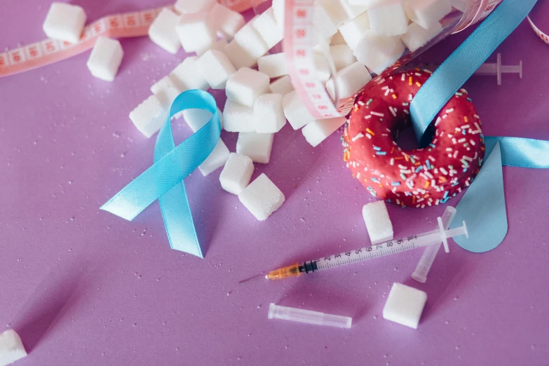 a donut sitting on top of a table covered in sugar cubes, by Julia Pishtar, antipodeans, syringes, ribbon, mauve and cyan, medical image