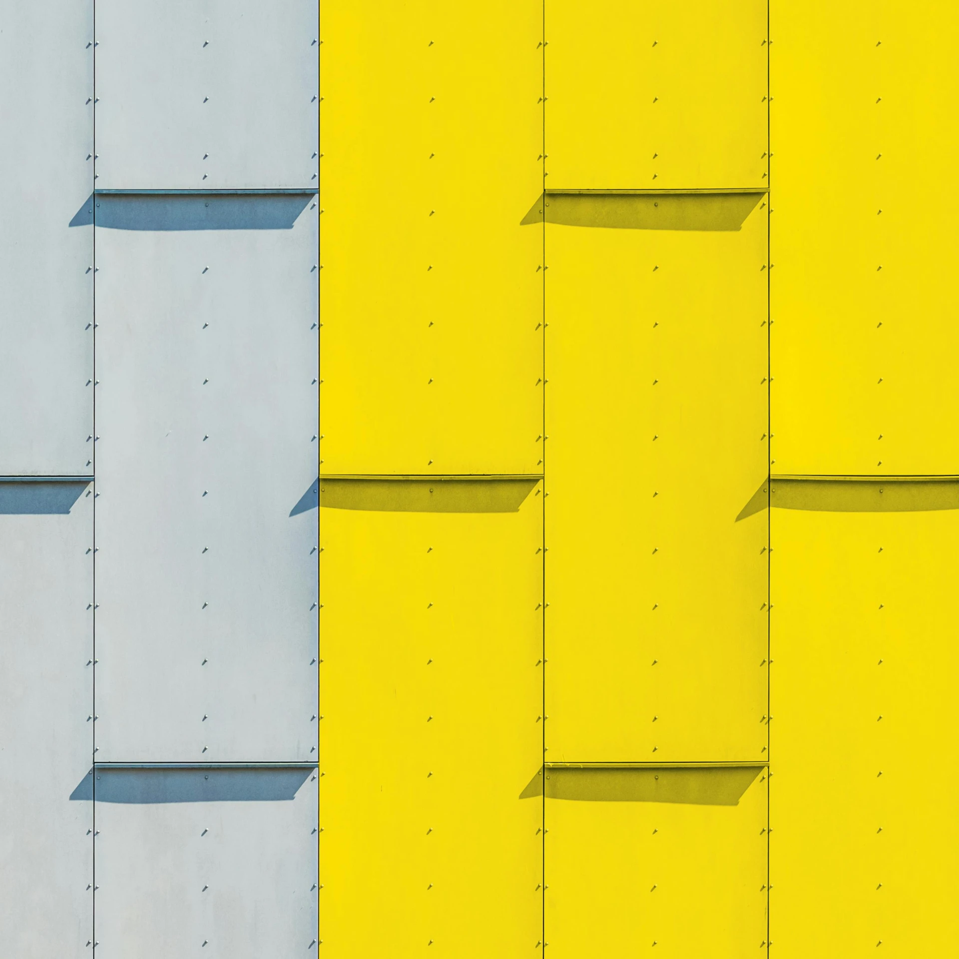 a red fire hydrant sitting in front of a yellow wall, a photo, inspired by Bauhaus, postminimalism, metal cladding wall, 3 colours, grey shift, colors: yellow