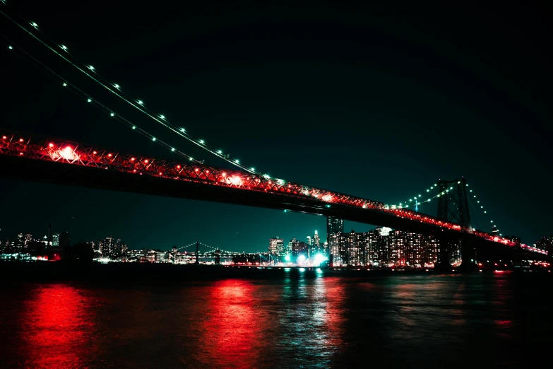 a bridge over a body of water at night, inspired by Elsa Bleda, unsplash contest winner, happening, red green black teal, new york skyline, pc wallpaper, teal silver red