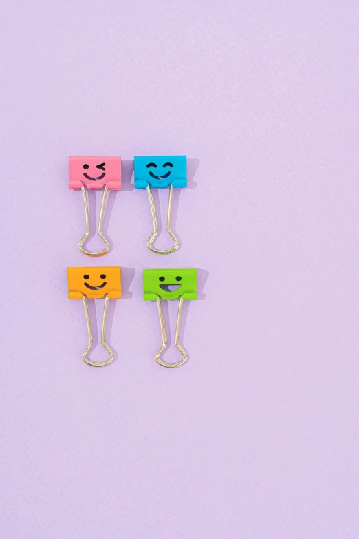 a group of paper clips with faces drawn on them, vivid pastel color scheme, small smile, 8, minimalistic aesthetics
