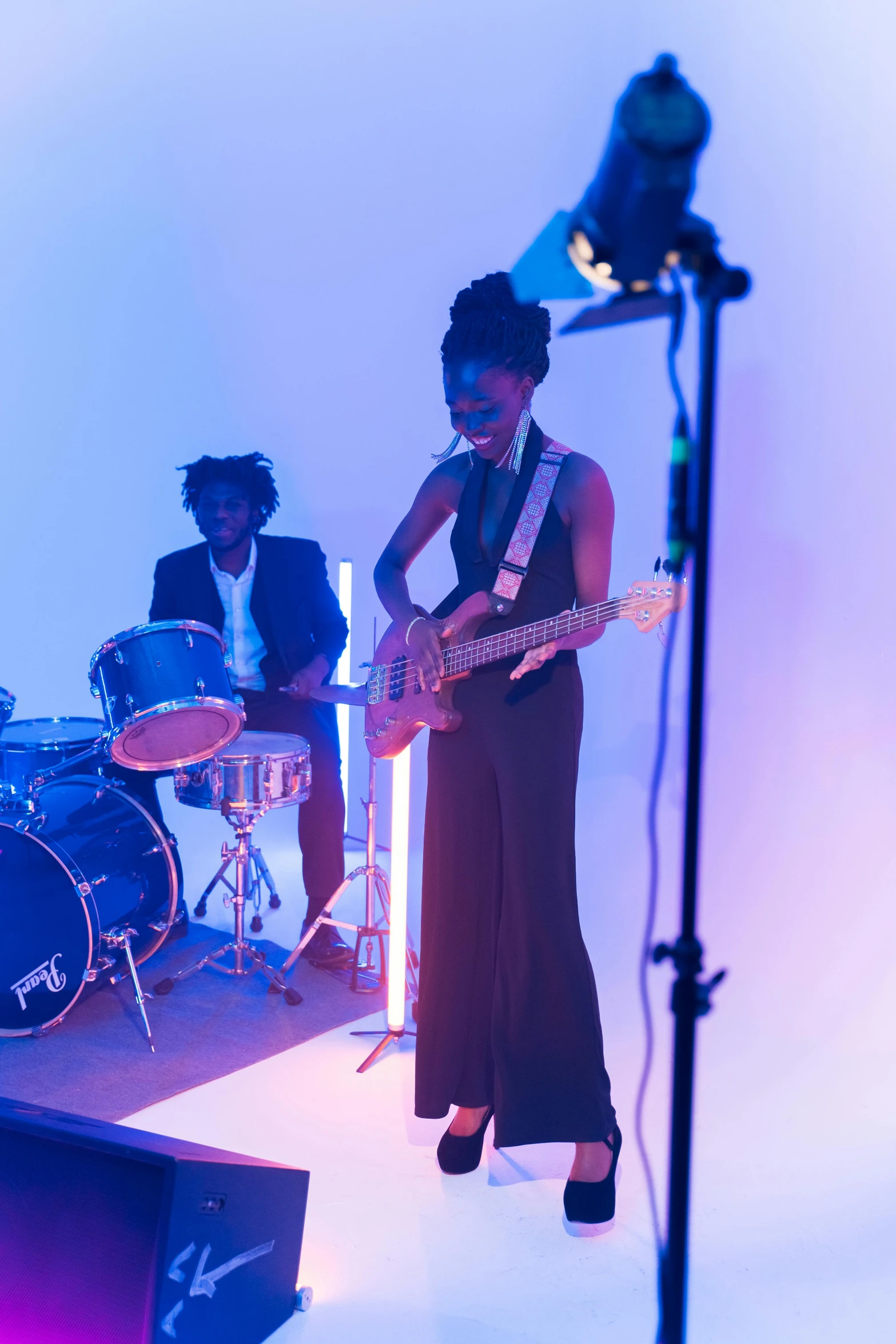 a woman that is standing in front of a microphone, an album cover, by Winona Nelson, pexels contest winner, black arts movement, band playing instruments, performing a music video, adut akech, bassist