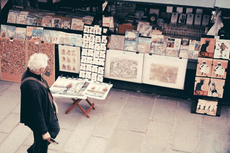a man that is standing in front of a table, a silk screen, by karolis strautniekas, pexels contest winner, temporary art, street market, drawing on a parchment, photo of a woman, from the distance