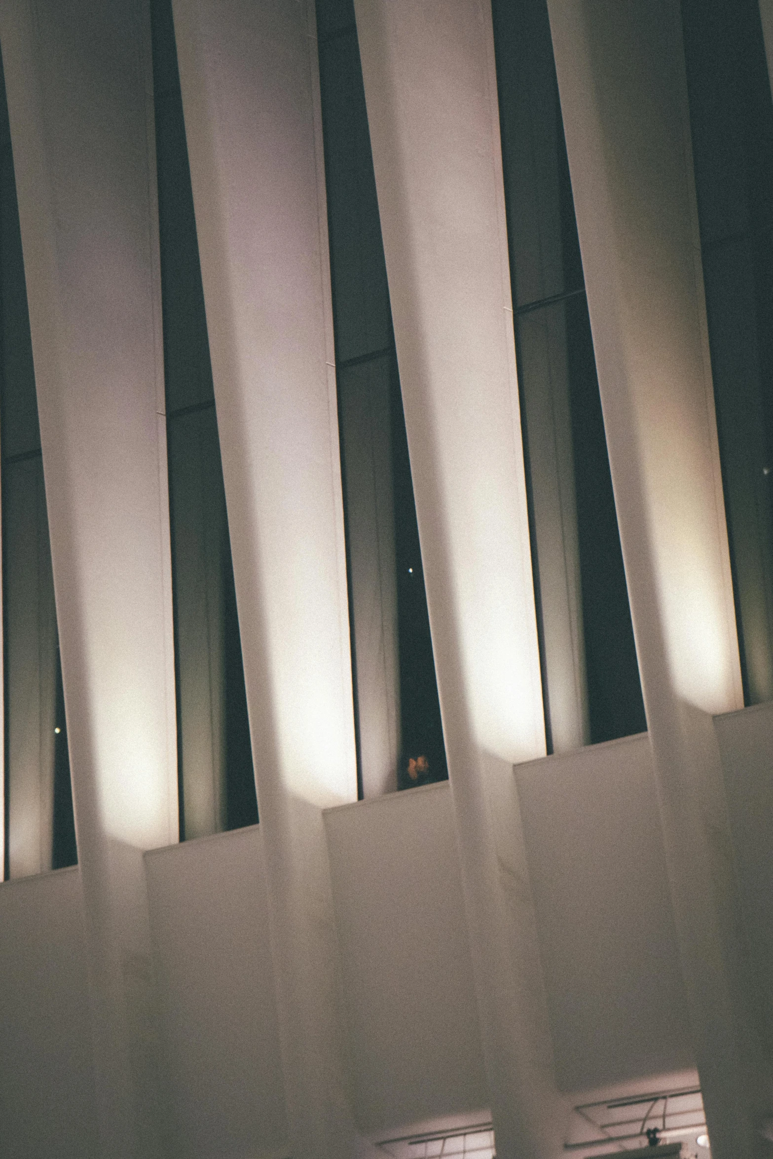 a couple of people that are standing in front of a building, inspired by Zaha Hadid, unsplash, light and space, pipe organ, spotlights from ceiling, abstract detail, brooklyn museum