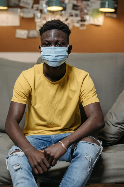a man sitting on a couch wearing a face mask, dark skin, lgbtq, surgery, multiple stories