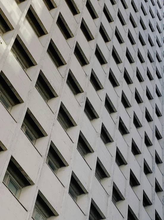 a clock that is on the side of a building, an album cover, inspired by Andreas Gursky, pexels contest winner, brutalism, grid of eye shapes, são paulo, window ( city ), zig zag