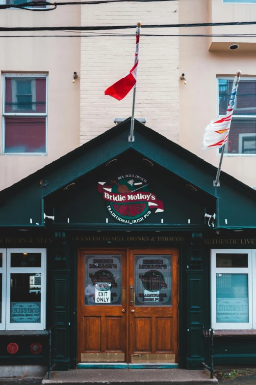 a building with a sign on the front of it, pexels contest winner, maple syrup sea, red flags holiday, broadway, thumbnail