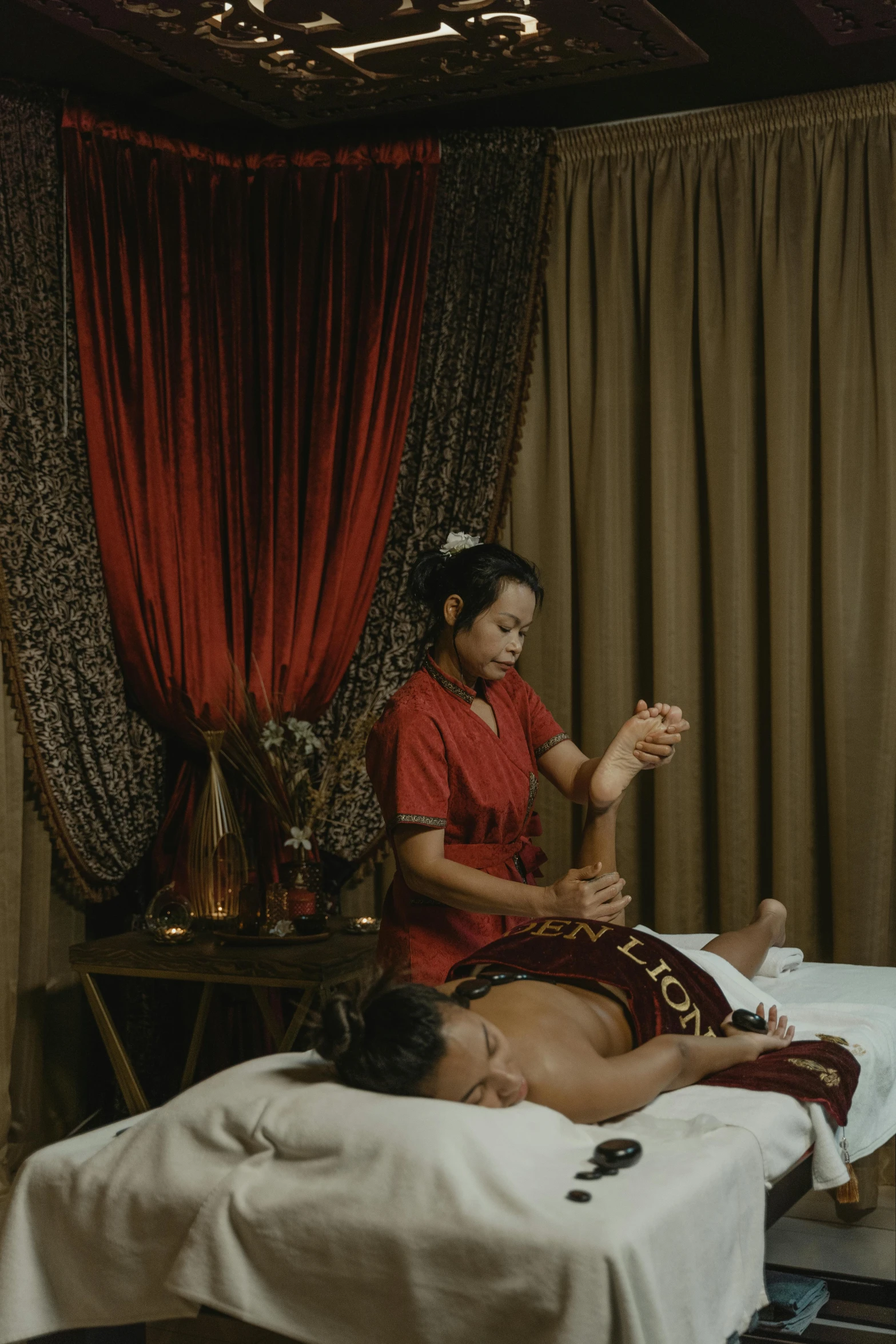 a woman getting a massage at a spa, a portrait, by Basuki Abdullah, wearing gilded red robes, square, [ cinematic, grey