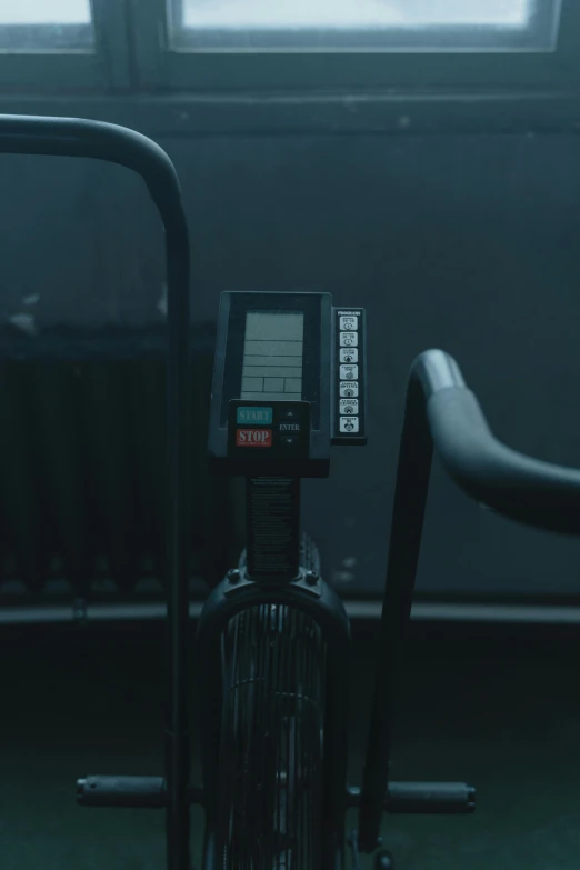 a stationary bike sitting in front of a window, inspired by Elsa Bleda, pexels contest winner, realism, in a pitch black room, medium close - up ( mcu ), in the high school gym, low quality footage