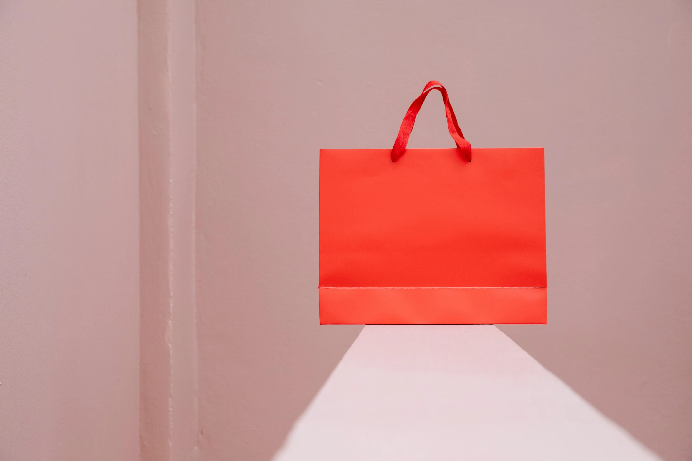 a red shopping bag sitting on top of a white counter, pexels contest winner, minimalism, des boutiques avec des neons, coral red, front facing, rectangle