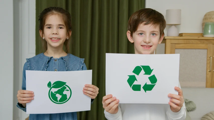 a couple of kids standing next to each other holding up signs, pexels contest winner, environmental art, recycled, avatar image, ad image, green energy