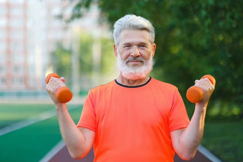 a man in an orange shirt holding two orange dumbbells, a photo, shutterstock, bushy white beard, an oldman, sports setting, 2263539546]