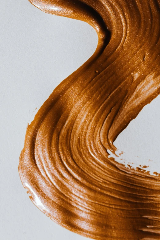 a close up of chocolate paint on a white surface, by Daniel Taylor, trending on pexels, caramel, organic lines, skincare, ochre