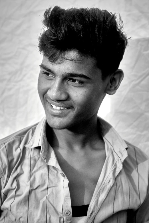 a black and white photo of a young man, by Sudip Roy, photorealism, smiling seductively, elvis, ((portrait)), tanned