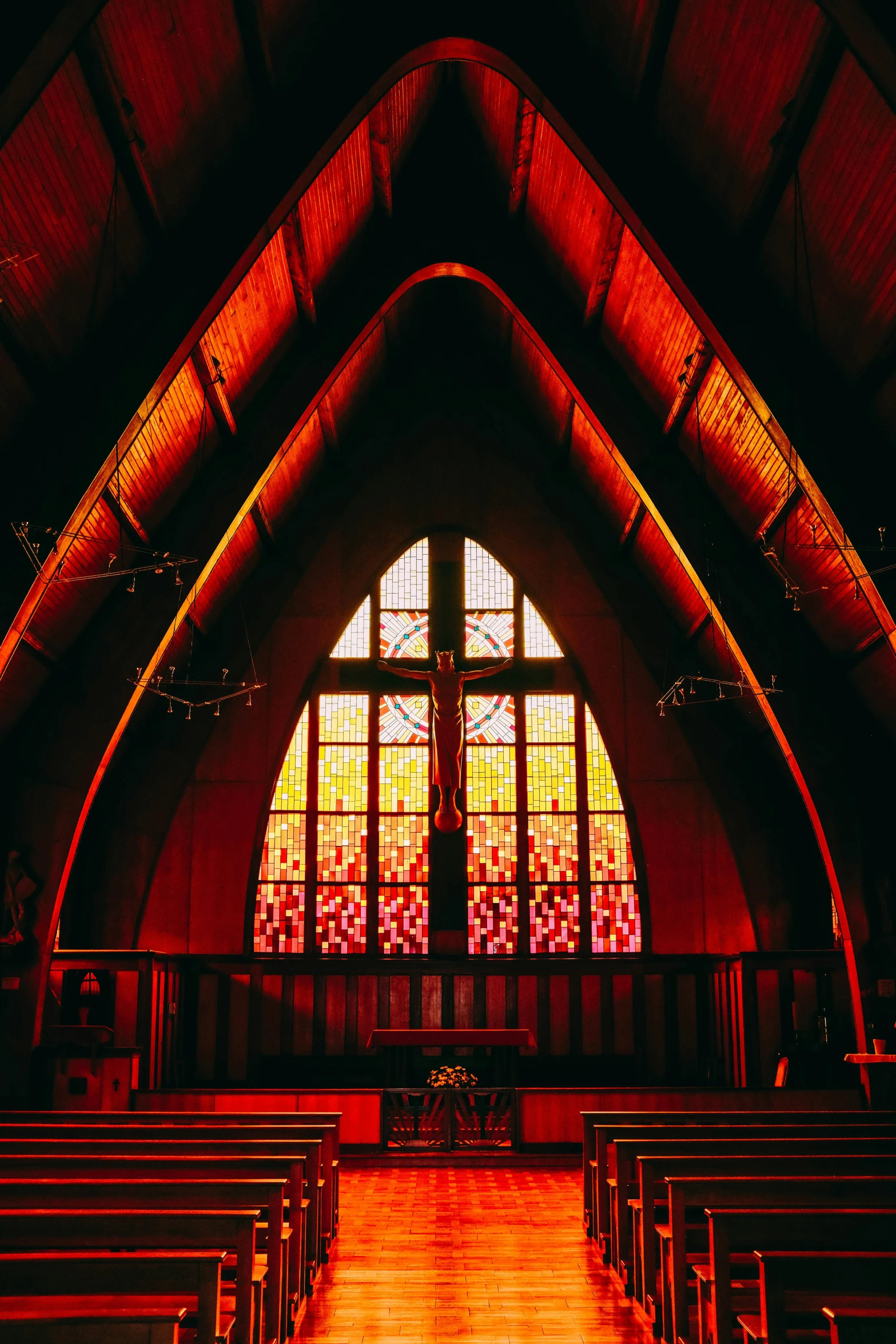 a church with stained glass windows and wooden pews, by Naondo Nakamura, unsplash, red and orange glow, 1990s photograph, in karuizawa, 1999 photograph