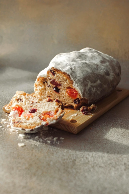 a loaf of bread sitting on top of a cutting board, cherry explosion, covered in white flour, fruit, icy