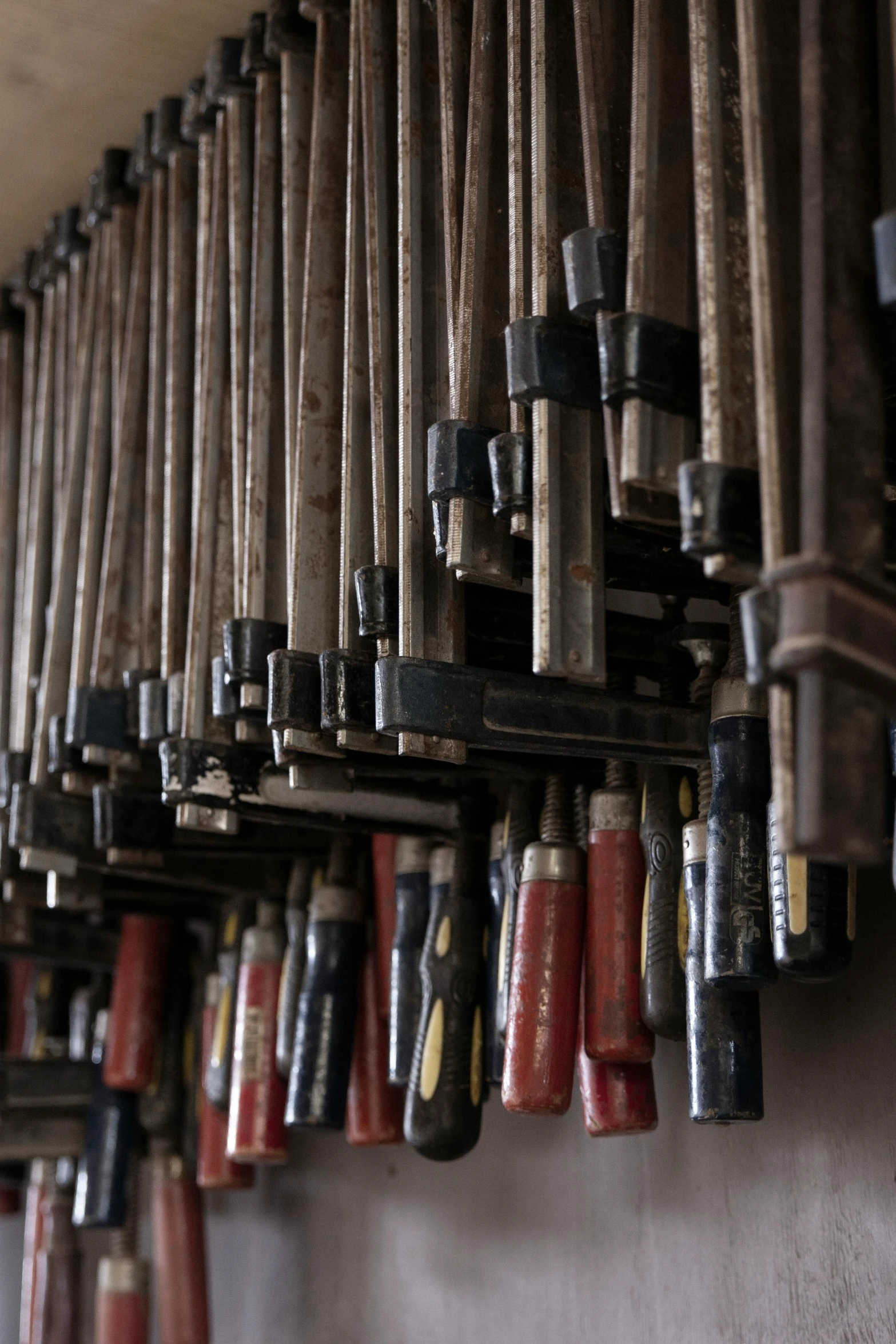 a bunch of tools hanging on a wall, an album cover, unsplash, mingei, pipe organ, pipes, photographed for reuters, close look