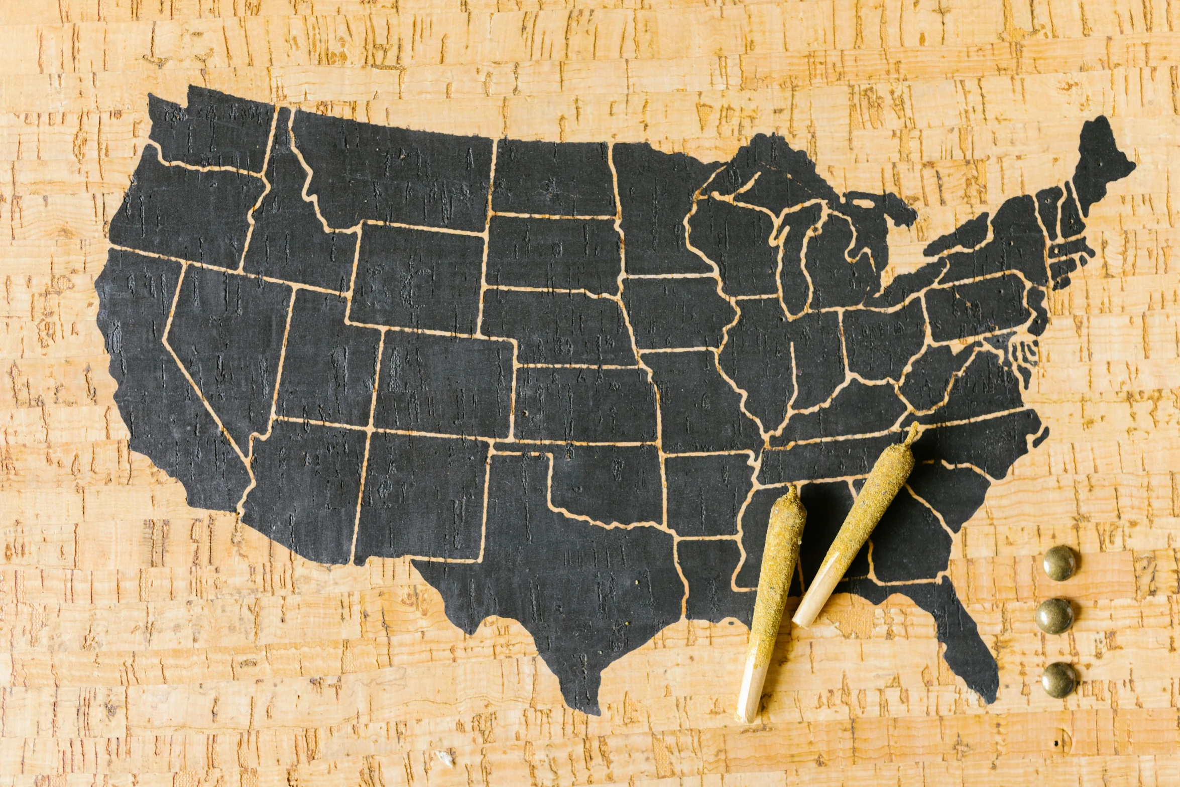 a map of the united states on a cork board, by Joe Stefanelli, pexels, folk art, smoking a joint, promo image, black. airports, wood carving