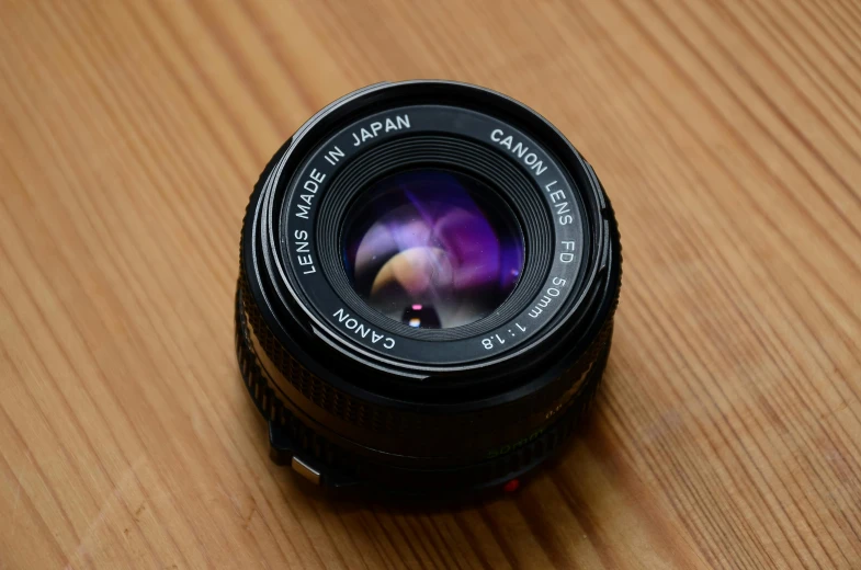 a camera lens sitting on top of a wooden table, by Adam Manyoki, unsplash, photorealism, canon 24mm, 2 4 mm iso 8 0 0 color
