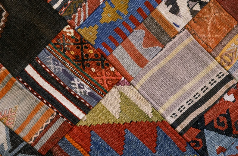 a close up of a colorful patchwork rug, half image, greek fabric, trending on textures. com, 2000s photo