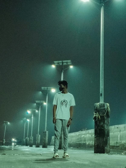 a man standing under a street light at night, a picture, plain white tshirt, assamese aesthetic, (mist filters), chillhop