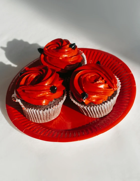 a red plate with three cupcakes on it, reddit, photorealism, black roses, high quality photo, 🎀 🧟 🍓 🧚, high resolution product photo