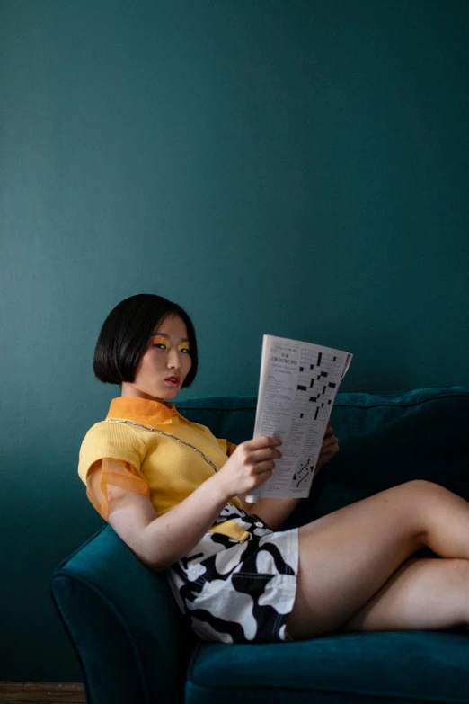 a woman sitting on a couch reading a magazine, inspired by Fei Danxu, wearing yellow croptop, cheongsam, short in stature, queer woman