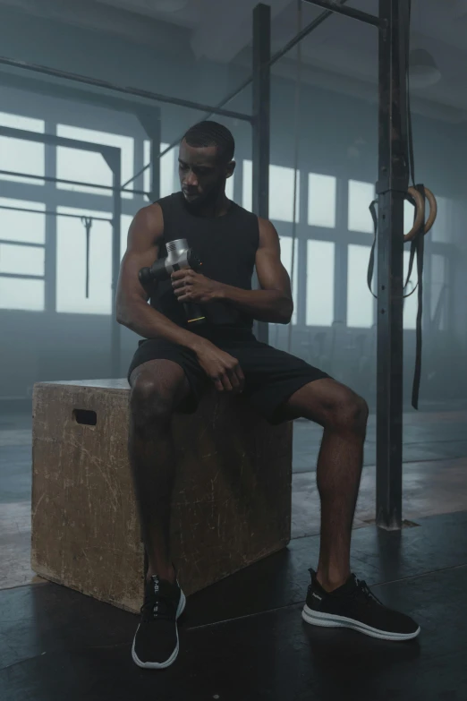 a man sitting on a box in a gym, pexels contest winner, renaissance, holding a bottle, still from a music video, body armor, black man