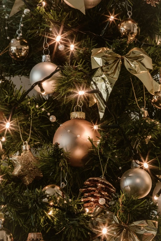 a close up of a christmas tree with ornaments, a portrait, inspired by Ernest William Christmas, pexels, baroque, muted lights, gold and silver tones, stars, glass bulbs